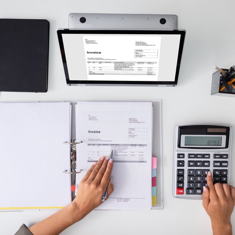 Businesswoman calculating tax at desk in office